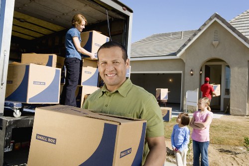 Relocation crew moving desks and office items in a local business area
